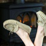 Beige British Made Suede Moccasin Slippers in front of log burner