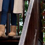 Tan slim fit sheepskin boots, female model walking down wooden steps