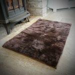 Sheepland Sheepskin Chocolate Pet Bed in lounge in front of fire place